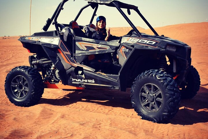 Experience the thrill of adventure as you navigate the picturesque dunes of the Arabian desert in a powerful Polaris 1000cc buggy creating unforgettable memories with every turn.